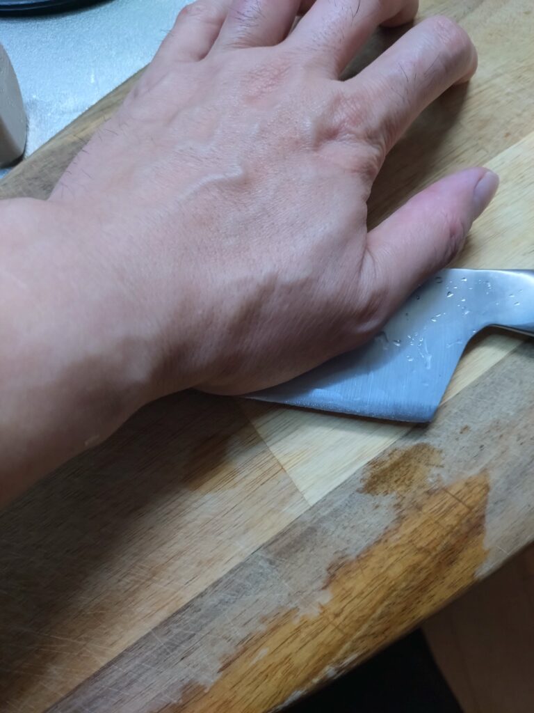 包丁の腹で、にんにくを軽くつぶす様子