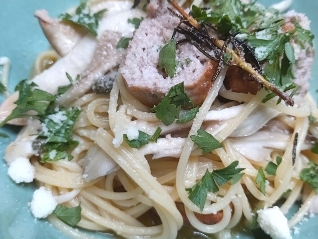 パセリとパルミジャーノをかけた、自家製サルシッチャときのこのパスタ