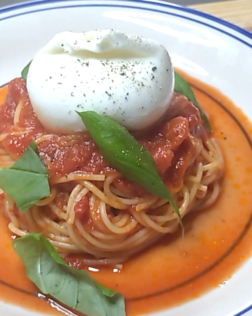 ブッラータを丸ごとのせ、バジルを添えたトマトソースのスパゲティ