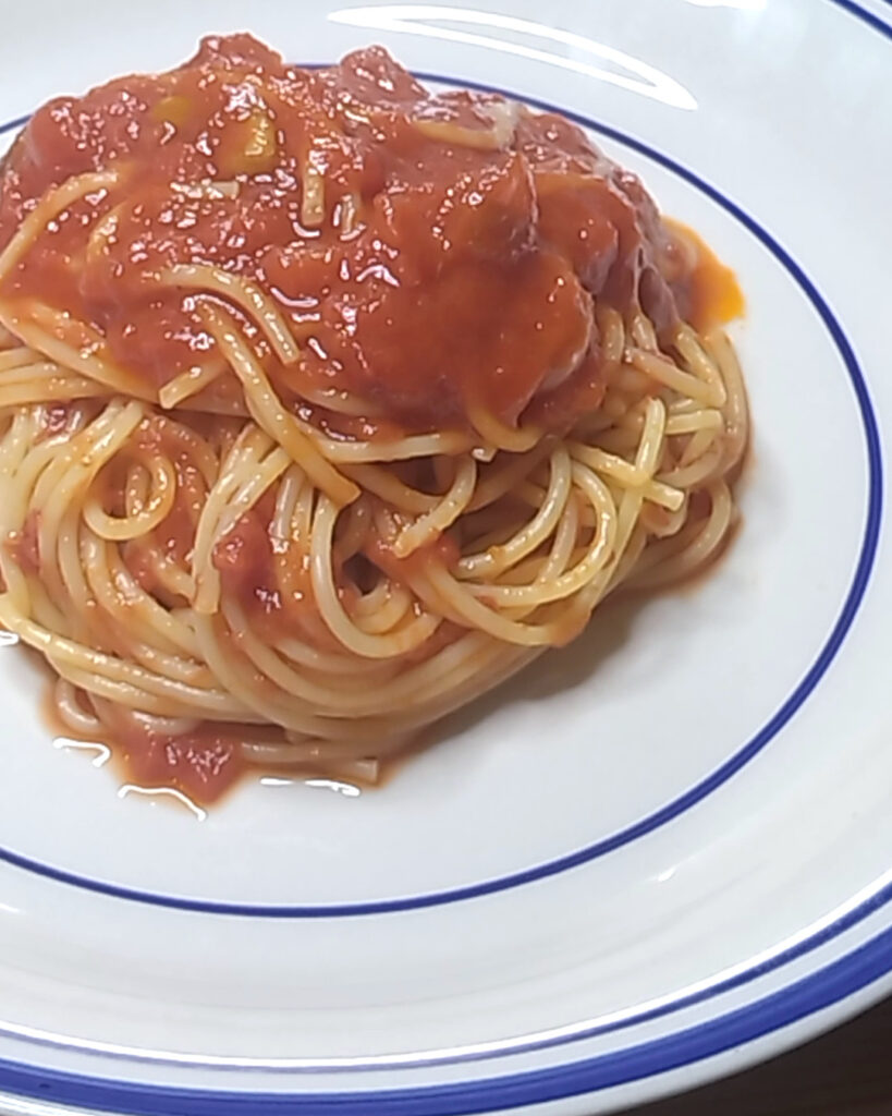 器に盛り付けた、ブッラータをのせる前のトマトソースのスパゲティ